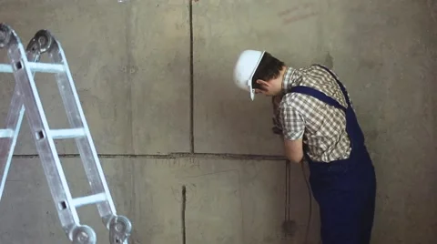 Builder with tool performs repair work Stock Footage 61724053