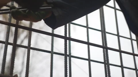 Builder twists wire fastening rods at construction site Stock Footage 312404954