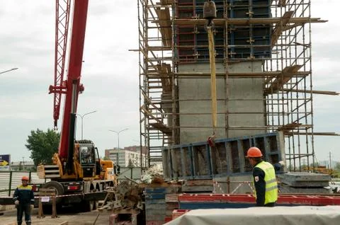 Builder in uniform and helmet operating with crane Stock Photos