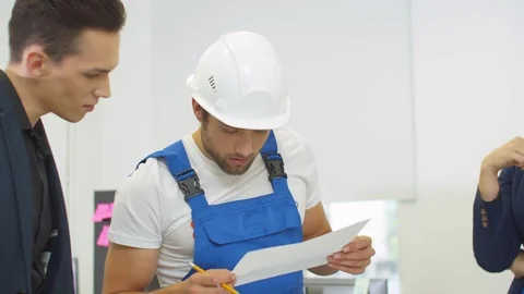 Builder in uniform explain project of houses to engineers Stock Footage 121812682