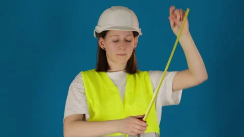Builder in uniform measures distance with retractable meter Stock Footage 273206167