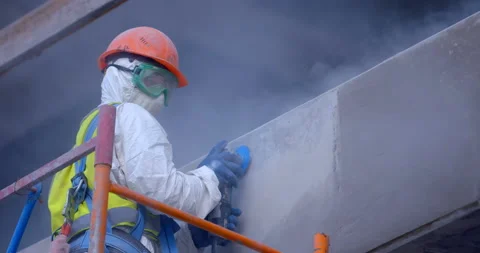 A builder in uniform is working on scaffolding on rough grinding the wall  Stock Footage 119625304