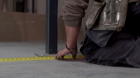 Builder uses a laser level device and a tape measure on construction site Stock Footage 78770737