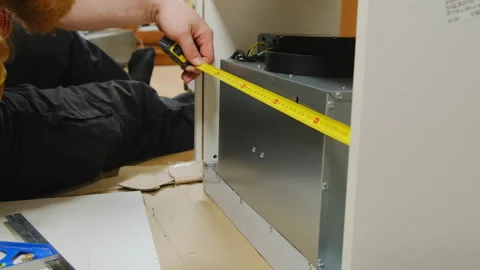 Builder uses tape measure for measuring width of cabinet Stock Footage 304401820