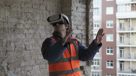 The builder uses virtual reality glasses and plans to reconstruct the building Stock Footage 131826694