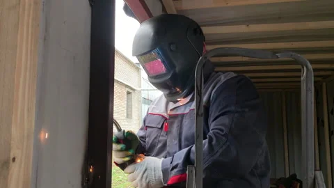 A builder uses a welding machine to make a window frame. Stock Footage 310652776