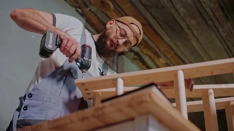 Builder using electrical screwdriver to create a wooden construction in studio Video stock 170502436