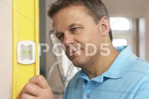 Builder Using Spirit Level On Wall Stock Photos