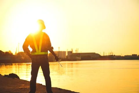 The builder wears a hat, holds the device, stands facing the sun Photos