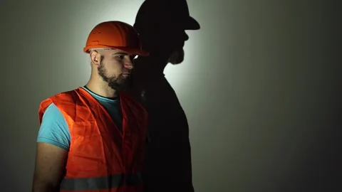 Builder on a white background. A man in uniform, in an orange helmet Stockbeeldmateriaal 256181321