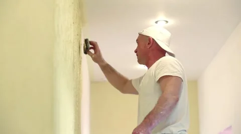 Builder with white cap is making relief pattern on the wall. Stock Footage 48958178