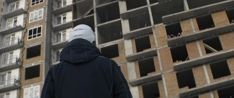 Builder in white helmet oversees construction progress of multi-story building Stock Footage 119496920
