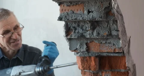 Builder work with building tool, break brick wall, pieces of brick and mortar Stock Footage 124305830