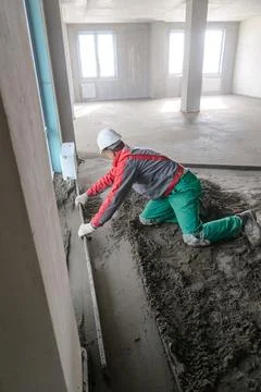 A builder in work clothes is doing his job Stock Photos