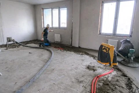 Builder in work clothes prepares tools and materials Stock Photos