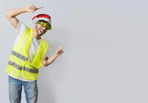 Builder worker with christmas hat pointing a christmas promotion. Builder e.. Stock Photos