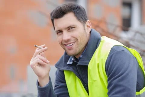 Builder worker with a cigarette smoke break Stock Photos