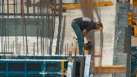 Builder worker cuts the construction armature with an angular grinding machine Stock Footage 76587335