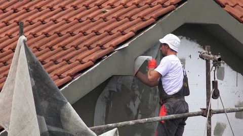 Builder worker facade building with sandpaper Stock Footage 77852748
