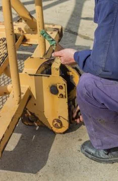 Builder worker greasing parts of the crane Stock Photos