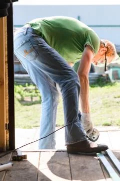 Builder worker with grinder machine cutting metal wood at construction site Fotos Stock