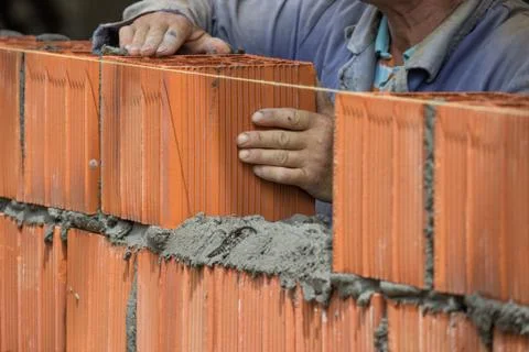Builder worker installing clay block wall, lay clay block Stock Photos