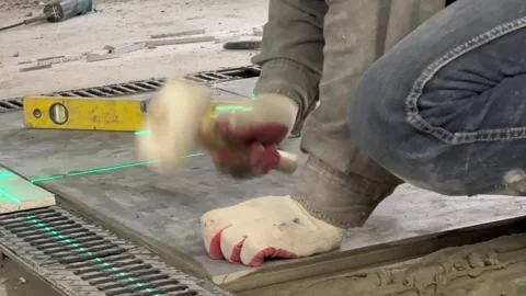 Builder worker installing floor a large ceramic tile at repair renovation work. Stock Footage 328528567