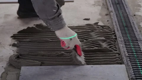 Builder worker installing floor a large ceramic tile at repair renovation work. Stock Footage 329798835