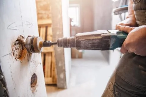 Builder worker pneumatic hammer drills hole in concrete brick wall with diamond Stock Photos