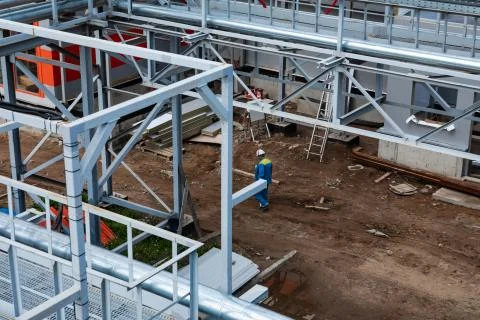 Builder worker in safety protective equipment on the construction site of a new Photos