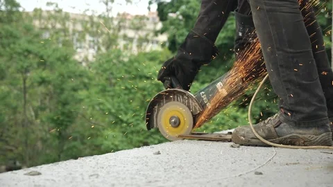 BUILDER WORKER is sawing cement with a grinder. SPARKS FLY AWAY Stock Footage 156785927