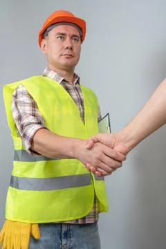 A builder, a worker shaking hands with a client to negotiate the construction Stock Photos