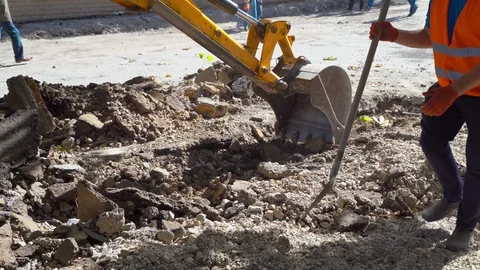 Builder worker working on an asphalt road with shovel at road construction site Stock Footage 117913166