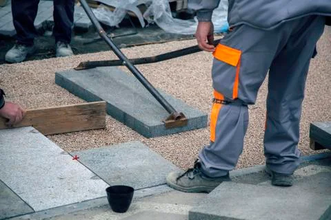 Builder workers lay large paving slabs Stock Photos