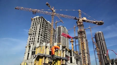 Builder works at against background of the construction site high-rise buildings Stock Footage