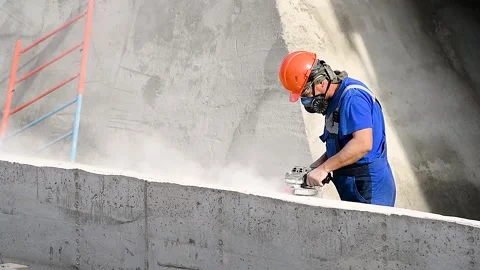 The builder works with an angle grinder Видео 222586798