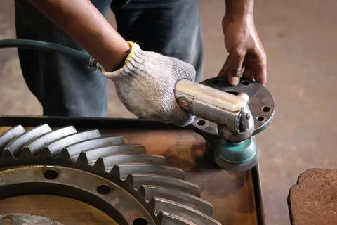 The builder works with an angle grinder. Stock Photos
