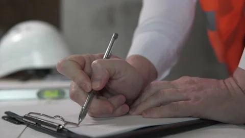 A builder works with blueprints at a construction site. Stock Footage 155845091