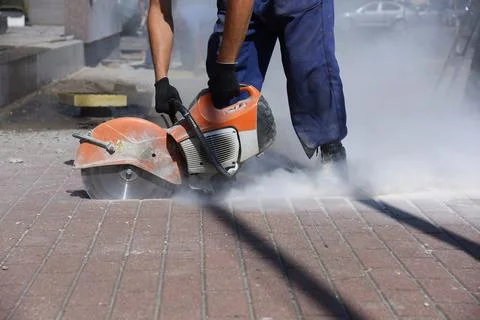 The builder works with a circular saw. Stock Photos