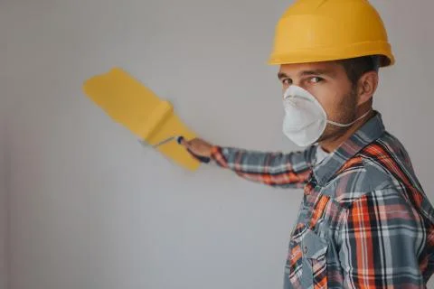 The builder works at the construction site and measures the ceiling. A worker 库存照片