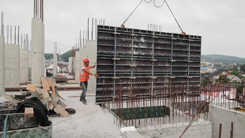 The builder works on the construction site. Installation of a large metal Stock Footage 248415498