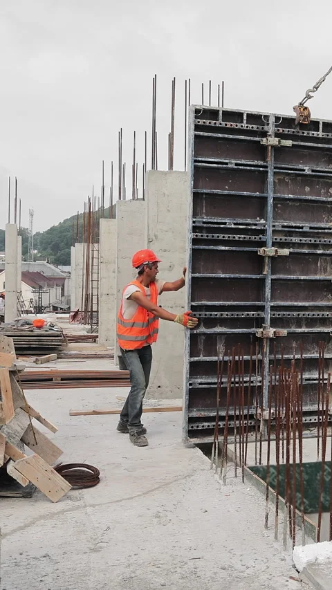 The builder works on the construction site. Installation of a large metal Stock Footage 317890856
