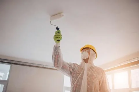 The builder works at the construction site . Worker with a paint roller. He i Stock-Fotos