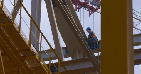 The builder works at height during the construction of the roof of new stadium Stock Footage 119622926