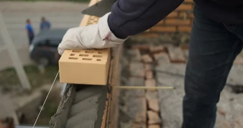 Builder works on laying external wall of building at low height, works fast Stock Footage 116813431
