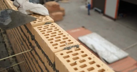 Builder works on laying external wall of building at low height, works fast Stock Footage 116813887