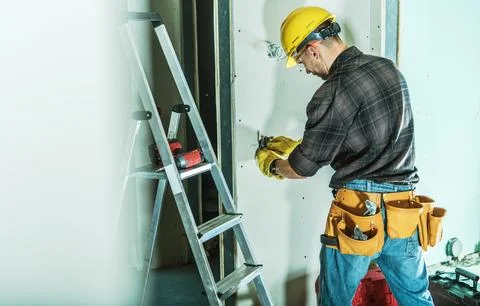 Builder Works on Wall Inside Construction Site Stock Photos