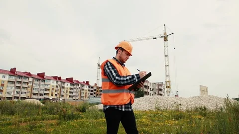 The builder writes data on the background of a house under construction. Video stock 129056494