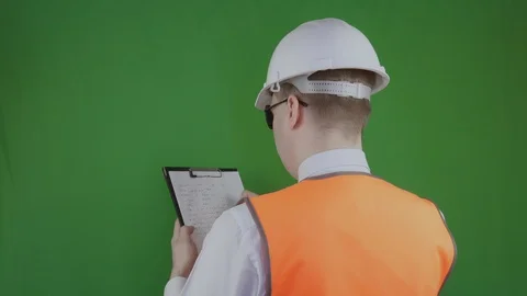 Builder writes data to the clipboard. Chromakey. Engineer in a white helmet and Stock Footage 113929708