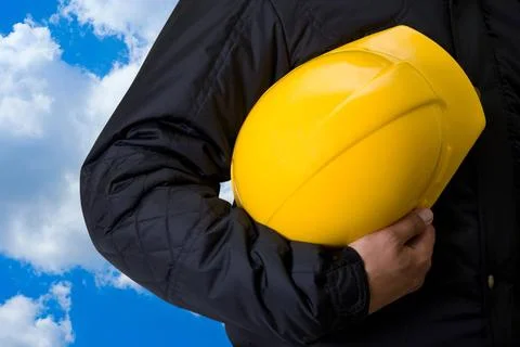Builder Yellow helmet at man hands on blue sky background Copyright: xZoon... Stock Photos